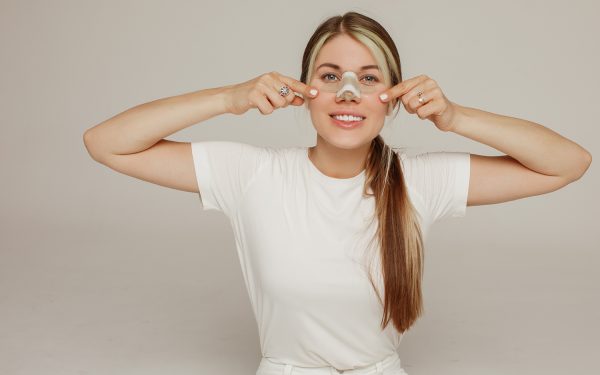 A young woman with a bandage on her nose after rhinoplasty rejoi rhinoplasty recovery
