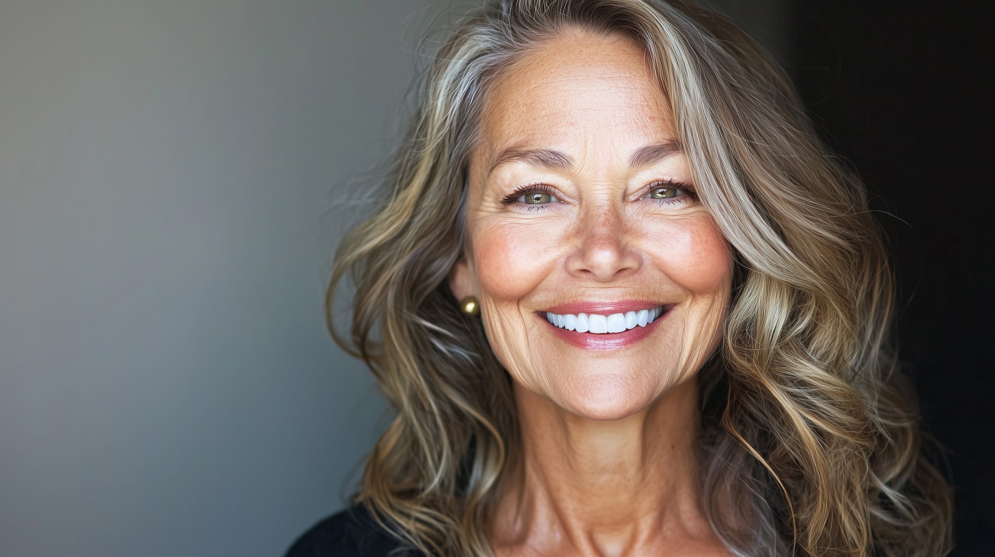 Elegant older woman with radiant smile and flowing wavy hair beautiful 60s and beyond woman